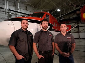 Kenn Borek Air pilots Wally Dobchuk, right, Sebastien Trudel, centre, and maintenance engineer Mike McCrae, left,  pose with the Twin Otter airplane they used in a successful medical evacuation of two researchers from Antarctica.