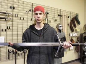 Layne Visser, a leather worker and chain mail builder, displays a 15th century scottish claymore sword at Dark Age Creations. Behind him, the 
 show board in the Calgary,  store stands mostly empty after thieves stole some very unique and dangerous handamade swords and other items. Jim Wells//Postmedia