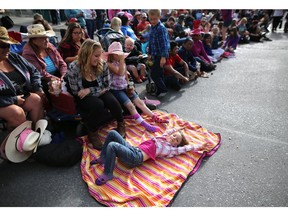 Lily Waisman,5, rests as she takes in the Calgary Stampede Parade in Calgary, Alta., on Friday July 8, 2016. Leah Hennel/Postmedia