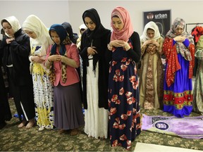 Muslim women mark the end of Ramadan with prayer during EID Festival at the Highland Park Community Association on Wednesday, July 6, 2016.
