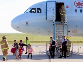 Passengers from Air Canada flight AC1159 from Toronto deplane in Lethbridge, Alta., Saturday, July 30, 2016 after being diverted from Calgary when the windshield sustained heavy hail damage. No injuries were reported from the 144 passengers and five crew members.