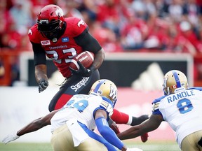 Calgary Stampeders Jerome Messam avoids a tackle by Julian Posey and Chris Randle of the Winnipeg Blue Bombers in CFL football in Calgary, Alta., on Friday, July 1, 2016. AL CHAREST/POSTMEDIA