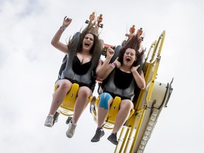 Raeleigh Aberg (L) and Laisa Kelly, both age 16, enjoy the Mach 3 ride on the midway during the Calgary Stampede Sneak-a-Peek in Calgary, Alta., on Thursday, July 7, 2016. Stampede would officially kick off the next day and last until July 17.