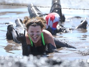 A competitor has some fun as she crawls through the mud during Rugged Maniac 5k Obstacle Race & Mud Run held at Spruce Meadows in Calgary, Alta on Saturday July 30, 2016. The event features about 30 different obstacles.  Jim Wells/Postmedia