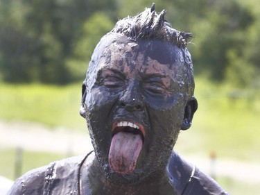 A muddy faced competitor catches his breath after completing the Rugged Maniac 5k Obstacle Race & Mud Run held at Spruce Meadows in Calgary, Alta on Saturday July 30, 2016. Jim Wells/Postmedia