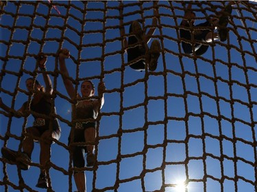 Competitors climb over the cargo net during the Rugged Maniac 5k Obstacle Race & Mud Run held at Spruce Meadows in Calgary, Alta on Saturday July 30, 2016. Jim Wells/Postmedia Jim Wells/Postmedia