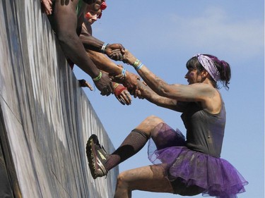 Competitors help each other conquer a gian wall during the Rugged Maniac 5k Obstacle Race & Mud Run held at Spruce Meadows in Calgary, Alta on Saturday July 30, 2016. Jim Wells/Postmedia
