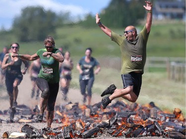 Competitors clear the fire obstacle during the Rugged Maniac 5k Obstacle Race & Mud Run held at Spruce Meadows in Calgary, Alta on Saturday July 30, 2016.  Jim Wells/Postmedia