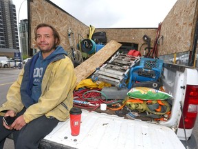 Sean Kilby sits on the tailgate of his truck with tools and equipment he uses for his siding work in Calgary, Alta on Thursday July 14, 2016. Kilby has been trying to make enough to take care of his baby, pay rent and make payments on his truck, but is struggling.