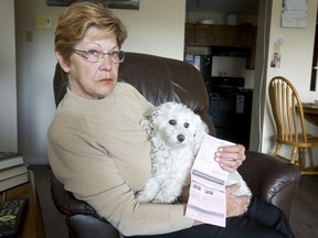 Johanne Schnurr and her 13-year-old dog Duchess hold their Calgary Animal and Bylaw Services ticket at home in Calgary on Tuesday, July 5, 2016. Schnurr was recently ticketed $100 for having the slow-and-quiet Duchess off-leash.