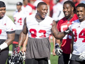 Micah Johnson walks with teammates Quayshawne Buckley (L), Randy Richards, and Frank Beltre (R) during the Calgary Stampeders training camp at McMahon Stadium in Calgary, Alta., on Tuesday, May 31, 2016. The regular season begins on June 25, when the Stamps head to B.C. Lyle Aspinall/Postmedia Network