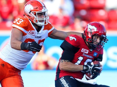Calgary Stampeders quarterback Bo Levi Mitchell, right, is tackled by BC Lions Craig Roh during CFL action at McMahon Stadium in Calgary, Alta.. on Friday July 29, 2016. Leah hennel/Postmedia