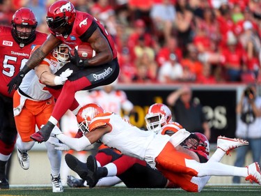 Calgary Stampeders Jerome Messam, left,  tries to evade a tackle from BC Lions Loucheiz Purifoy during CFL action at McMahon Stadium in Calgary on July 29, 2016.