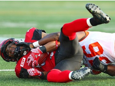 Calgary Stampeders Marquay McDaniel is tackled by Solomon Elimimian of the BC Lions during CFL football in Calgary, Alta., on Friday, July 29, 2016. AL CHAREST/POSTMEDIA
