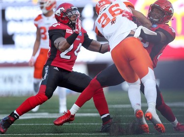 Calgary Stampeders Joe Burnett, left and Jamar Wall, right, tackle BC Lions Anthony Allen, middle, during CFL action at McMahon Stadium in Calgary, Alta.. on Friday July 29, 2016. Leah Hennel/Postmedia