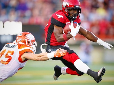 Calgary Stampeders Roy Finch avoids a tackle by Jason Arakgi of the BC Lions during CFL football in Calgary, Alta., on Friday, July 29, 2016. AL CHAREST/POSTMEDIA