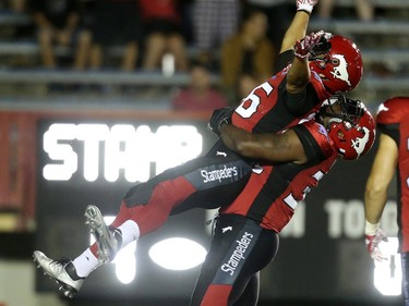 Calgary Stampeders Anthony Parker, left, is lifted by teammate Jerome Messam after scoring a touchdown on the BC Lions during CFL action at McMahon Stadium in Calgary, Alta.. on Friday July 29, 2016. Leah hennel/Postmedia