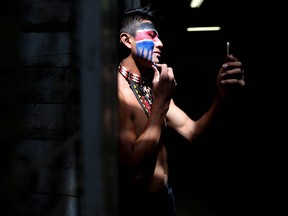 Steven Wolftail from Piikani and Stoney Nation applies war paint before riding with six other braves to kick-off the rodeo at the Calgary Stampede in Calgary, Alta., on Wednesday, July 13, 2016.