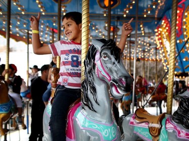 Syrian refugee Mohamad Alsalamat, 8, enjoys a ride on the carousel during his first Calgary Stampede in Calgary, Alta., on Wednesday July 13, 2016. Leah Hennel/Postmedia