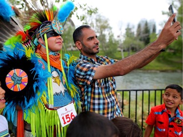 Syrian refugee Tareq Alzain, right, takes a selfie with Anthony Clearsky at Indian Village during his first Calgary Stampede in Calgary, Alta., on Wednesday July 13, 2016. Leah Hennel/Postmedia