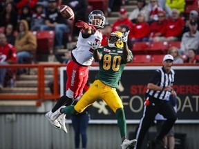 Edmonton Eskimos' Bryant Mitchell, right, looks on as Calgary Stampeders' Tommie Campbell swats away the ball during first half CFL pre-season football action in Calgary, Saturday, June 11, 2016.THE CANADIAN PRESS/Jeff McIntosh ORG XMIT: JMC104