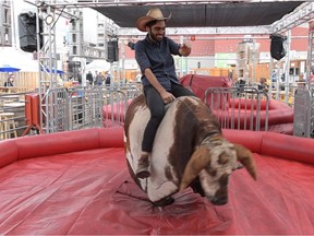 Toronto Sal rides a mechanical bull for the first time at the 2016 Calgary Stampede in Calgary, Alta., on Tuesday, July 12, 2016. Elizabeth Cameron/Postmedia