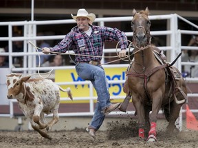 Tuf Cooper of Weatherford, Tex., works his calf in tie-down roping on Day 5 of the Calgary Stampede Rodeo in Calgary, Alta., on Tuesday, July 12, 2016. Cowboys compete for 10 days for a piece of the rodeo's $2 million in prize money. Lyle Aspinall/Postmedia Network