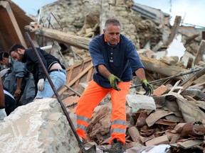 Rescuers clear debris while searching for victims in damaged buildings after a strong heartquake hit Amatrice on August 24, 2016. Central Italy was struck by a powerful, 6.2-magnitude earthquake in the early hours, which has killed at least three people and devastated dozens of mountain villages. Numerous buildings had collapsed in communities close to the epicenter of the quake near the town of Norcia in the region of Umbria, witnesses told Italian media, with an increase in the death toll highly likely.
