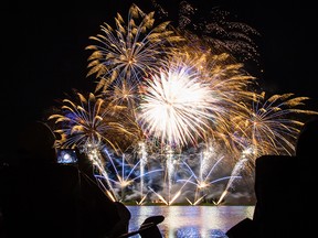 A spectator takes video with his cell phone as fireworks light up the sky at Globalfest 2016 at Elliston Park in Calgary, on August 25, 2016. --  (Crystal Schick/Postmedia)