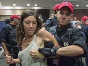 A demonstrator is taken away by a police officer after disrupting the National Energy Board public hearing into the proposed $15.7-billion Energy East pipeline project on Monday, Aug. 29, 2016 in Montreal.