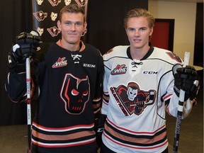 Beck Malenstyn and Jake Bean show off the new Calgary Hitmen Jerseys for the 2016-17 season at the Scotiabank Saddledome in Calgary, Ab., on Aug. 31, 2016. Two notable differences on the jerseys are the added stripes on the hem and sleeves, and the black logo appearing on the black jersey.