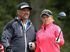 Brooke Henderson takes with her dad Dave as she gets ready to take a swing during an afternoon of practice at Priddis Greens Golf and Country Club west of Calgary, Alta., on Tuesday August 23, 2016. Henderson is in town to compete in the Canadian Pacific Women's Open.  Leah Hennel/Postmedia