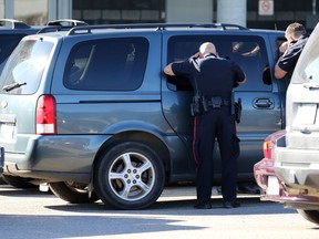 Police investigate a suspect van in the parking lot of the Huntington Hills Superstore following an early morning double stabbing on nearby Huntcroft Road in Calgary on Monday August 15, 2016.