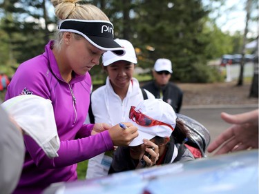 Canadian Brooke Henderson signs autographs for fans during the Pro-Am at Priddis Greens Golf and Country Club west of Calgary, Alta., on Wednesday August 24, 2016.