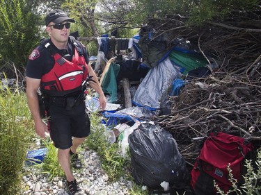 Calgary Police Marine Unit Constable Chris Terner walks through a squalorous illegal encampment hidden from view in underbrush along the banks of the Bow River.