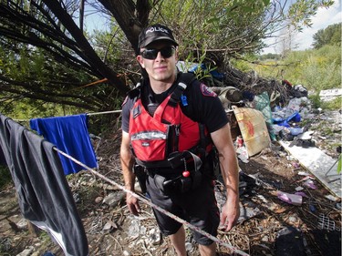 Calgary Police Marine Unit Constable Chris Terner checks out a squalorous illegal encampment hidden from view along the banks of the Bow River near Inglewood Golf Club Monday, Aug. 8, 2016.