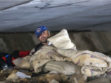 Homeless man Jamie Felthan peers out from a sleeping bag in his encampment on the Elbow River beneath the Macleod Trail bridge Monday, Aug. 8, 2016.