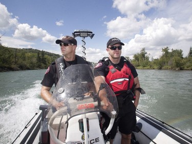 Calgary Police Marine Unit Constables Alasdair Robertson-More, left, and Chris Terner patrol the Bow River near Edworthy Park looking for illegal encampments.