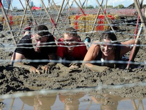 Rob Day along with his daughter Brienna age 16, and nephew Noah, 14, all of Edmonton, test out the Mud Pit on the Spartan Race course Friday August 12, 2016 at Blackfoot Motor Sports Park. They were doing a test run of the facility in advance of the obstacle course race tomorrow. Over 4000 competitors will try the 5 kilometre, 23 obstacle challenge. The Day's are running as  the Mud Dogs team. (Ted Rhodes/Postmedia)
