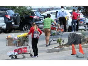 Cars and people line the parking lot of the Calgary Food Bank Friday August 5, 2016. The food bank has seen a marked increase in usage due to the ongoing Calgary recession. (Ted Rhodes/Postmedia)