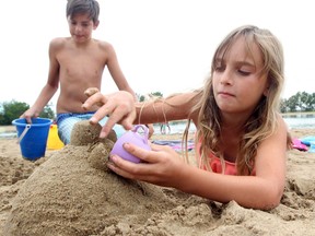 Children work on sand castles at Sikome Lake last summer — before an admission fee was imposed at the swimming hole this June.