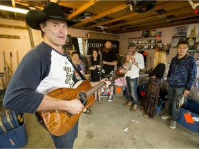 Corb Lund plays and sings his song Five Dollar Bill at his merchandise garage sale in Calgary, Alta., on Saturday, Aug. 6, 2016. The country musician was selling off a stash of his leftover merchandise.