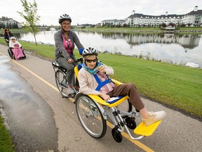 Ninety-nine-year-old Helen Mutchler happily takes a ride in a new bicycle courtesy of physiotherapist Elva Rodriguez outside of the Newport Harbour Care Centre in Calgary, Alta., on Monday, Aug. 8, 2016. The long-term seniors home recently purchased the bike for wheelchair-bound residents.