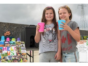 Dylan Woods, 9, and Jacey Molinelli, 8, set up a lemonade stand at the Calgary Zoo to raise money for endangered species, seen here in Calgary, Alta., on Sunday, Aug. 7, 2016. The girls will be returning monthly to the zoo to continue their sales, with all donations being given to the Calgary Zoo to fund their wildlife conservancy programs. Elizabeth Cameron/Postmedia
