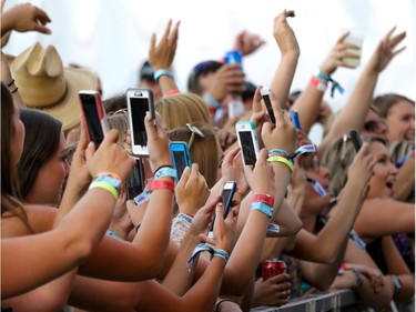 Fans scream and grab pictures as Chris Janson performs at day 2 of Country Thunder at Prairie Winds Park in Calgary, Ab., on Saturday August 20, 2016. Mike Drew/Postmedia