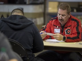 Terry Humphries, security event supervisor, left, interviews an applicant for a security position at the Calgary Sports and Entertainment job fair at the Saddledome in Calgary, on Aug. 23, 2016.