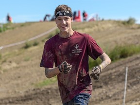 Phil Arsenault, 19, who has cerebral palsy, runs in the Calgary Spartan Race at the Wild Rose MX Park in Calgary, Alta., on Saturday, Aug. 13, 2016. It is Arsenault's third Spartan Race this summer.