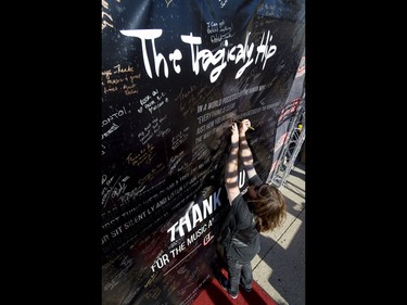 Chad Vallier signs a large thank-you poster at a CJAY 92 booth before a Tragically Hip concert at the Scotiabank Saddledome in Calgary, Alta., on Monday, Aug. 1, 2016. The show was part of the iconic band's final tour, happening in the wake of Downie's incurable brain cancer diagnosis. Lyle Aspinall/Postmedia Network