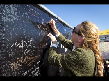 Kathy Gammon signs a large thank-you poster at a CJAY 92 booth before a Tragically Hip concert at the Scotiabank Saddledome in Calgary, Alta., on Monday, Aug. 1, 2016. The show was part of the iconic band's final tour, happening in the wake of Downie's incurable brain cancer diagnosis. Lyle Aspinall/Postmedia Network