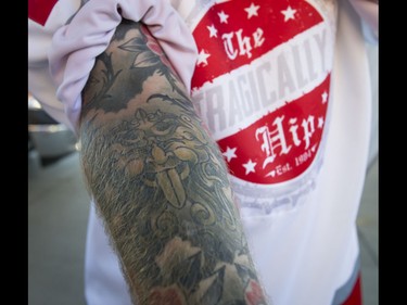 Kyle Kiiver shows off his Tragically Hip tattoo before a Tragically Hip concert at the Scotiabank Saddledome in Calgary, Alta., on Monday, Aug. 1, 2016. The show was part of the iconic band's final tour, happening in the wake of Downie's incurable brain cancer diagnosis. Lyle Aspinall/Postmedia Network